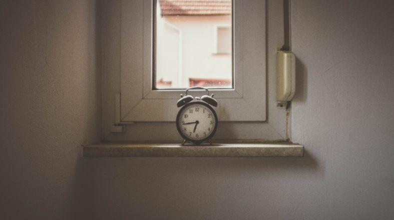 old clock is standing on the window from the inside