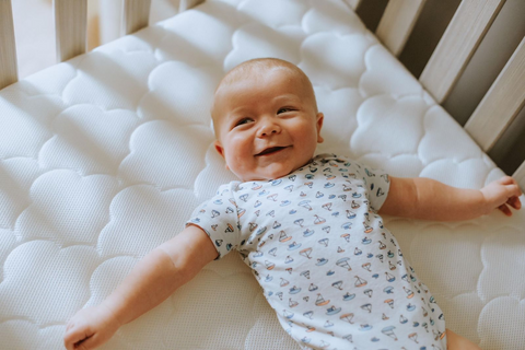 Baby laying in crib before being swaddled