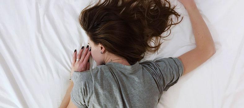 Image of a young woman power napping on her back